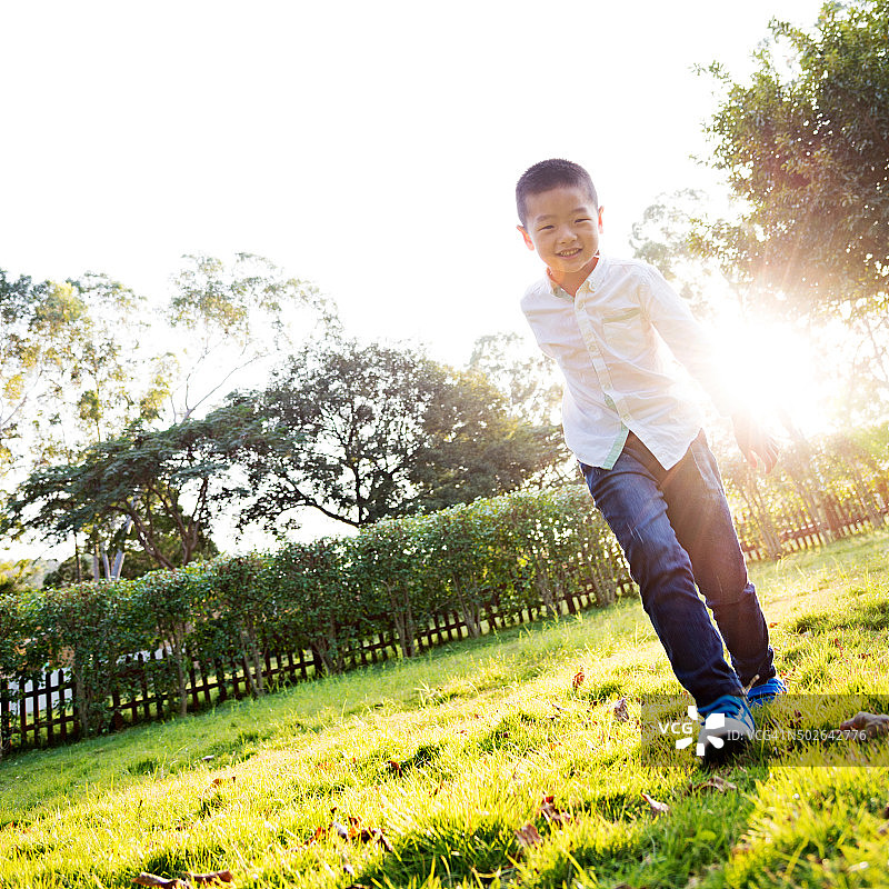 快乐的男孩在公园里奔跑图片素材