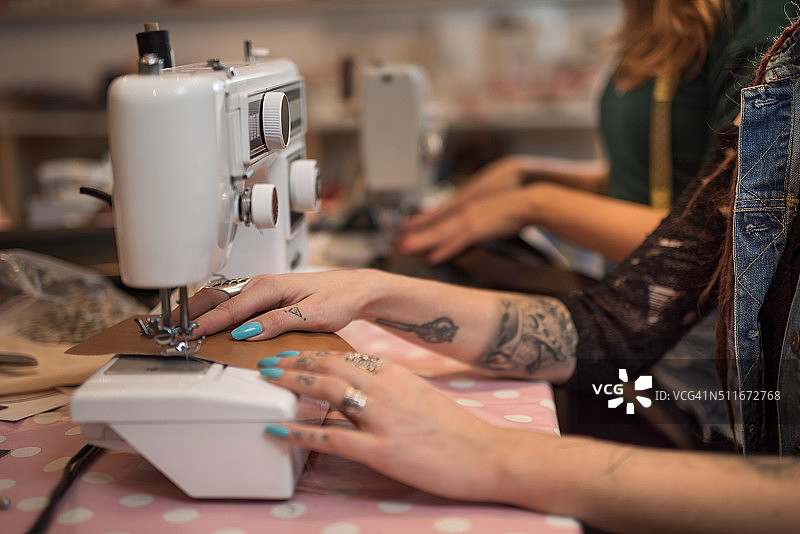 一个面目全非的女裁缝在机器上缝制。图片素材