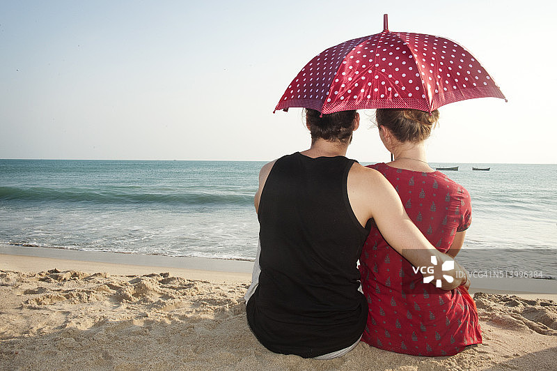一对可爱的情侣在海滩上拥抱着彼此图片素材