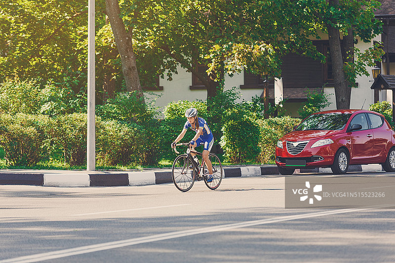 女自行车手在城市道路上骑赛车图片素材