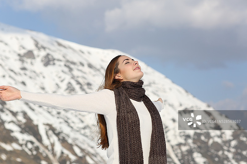 在冬天举起手臂呼吸新鲜空气的女人图片素材