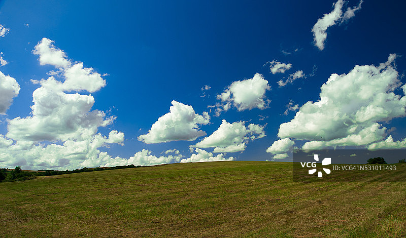 绿色的田野，蓝色的天空和淡淡的云彩图片素材