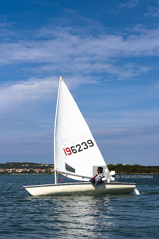 一个年轻人驾驶着奥林匹克级激光帆船图片素材