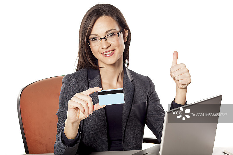 微笑的女商人拿着信用卡，竖起大拇指图片素材