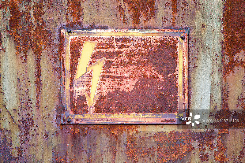 非常旧，生锈的电气储物柜门。警告标志。图片素材