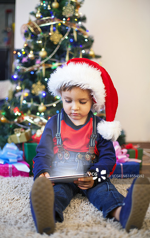 婴儿在圣诞老人的帽子和圣诞礼物-智能手机图片素材