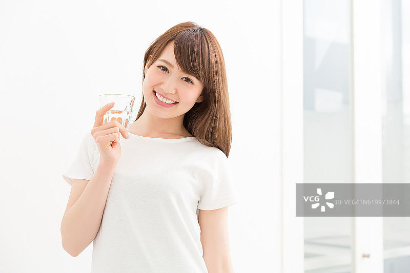一位日本妇女，手里拿着一杯水图片素材