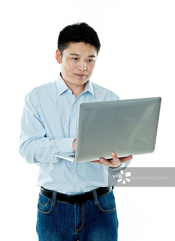 年轻的亚洲人拿着一台笔记本电脑图片素材