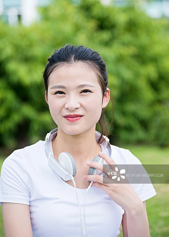 年轻的亚洲女子戴着耳机图片素材