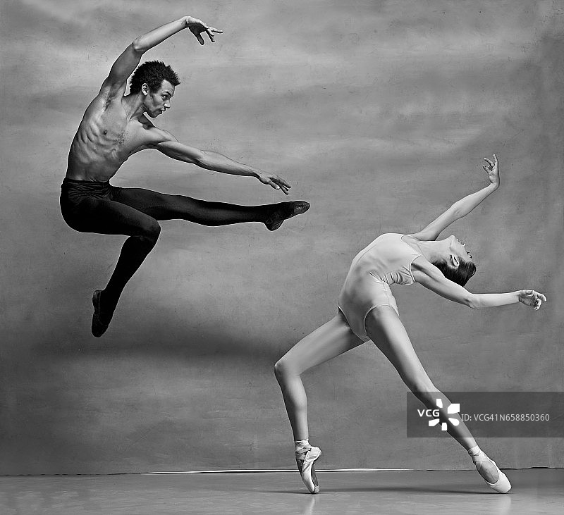 一对芭蕾舞者在灰色背景下摆姿势图片素材