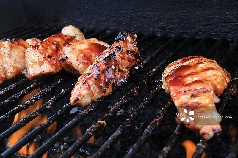 在烤架上烤制的家禽肉，涂上烧烤酱图片素材