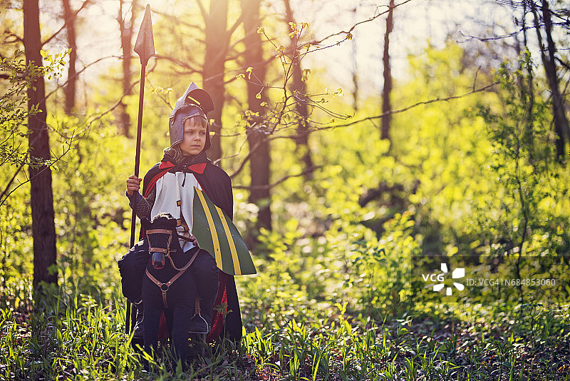 小骑士在森林里骑着玩具马图片素材