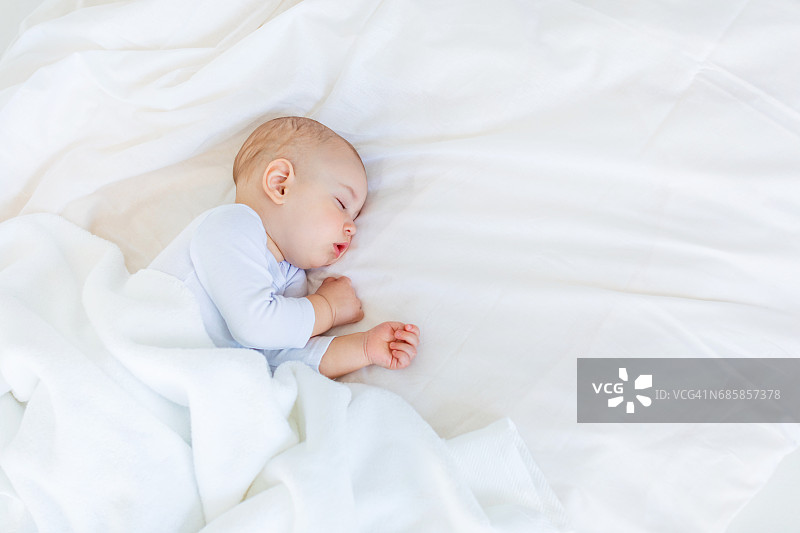 特写可爱的小男孩睡在床上，1岁的婴儿概念图片素材