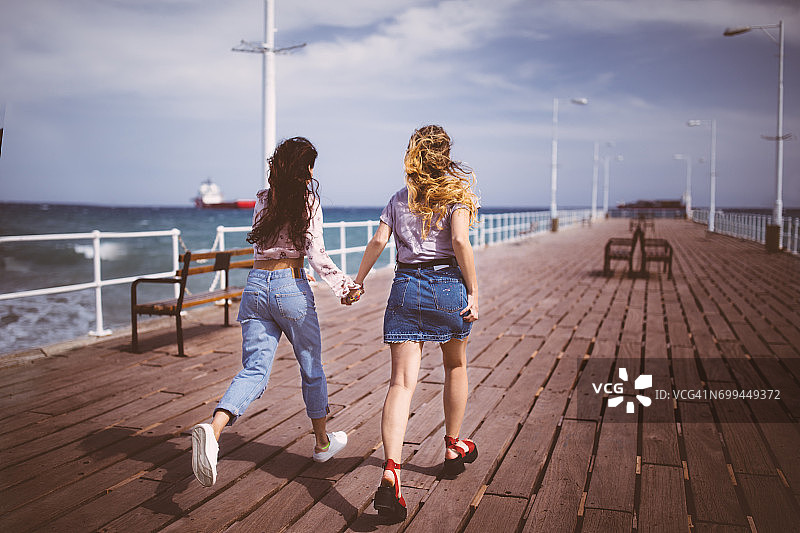 暑假的少女们在防波堤上奔跑图片素材