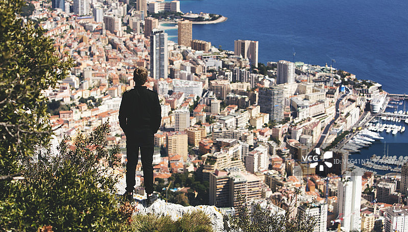 一个黑衣人站在城市的背景上图片素材