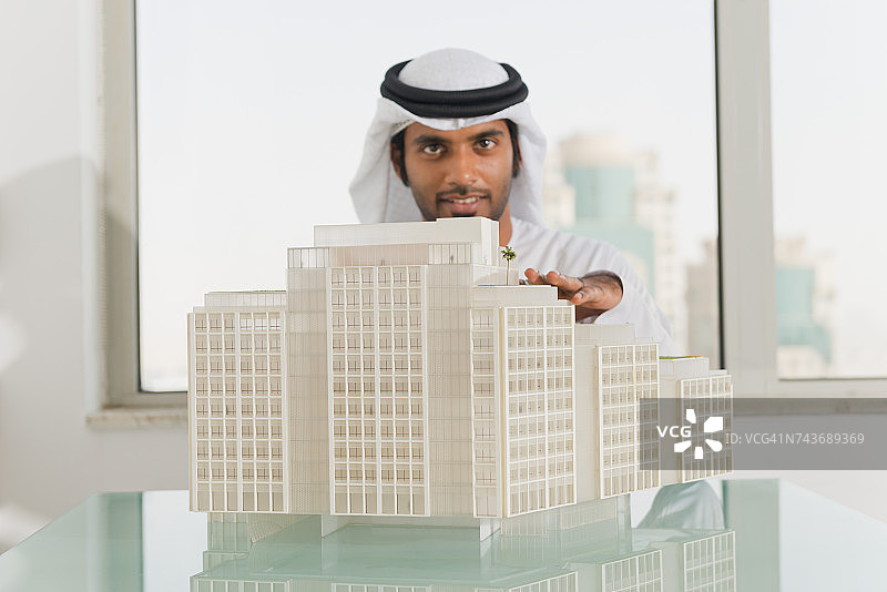 阿联酋商人的肖像和建筑模型在办公室。图片素材