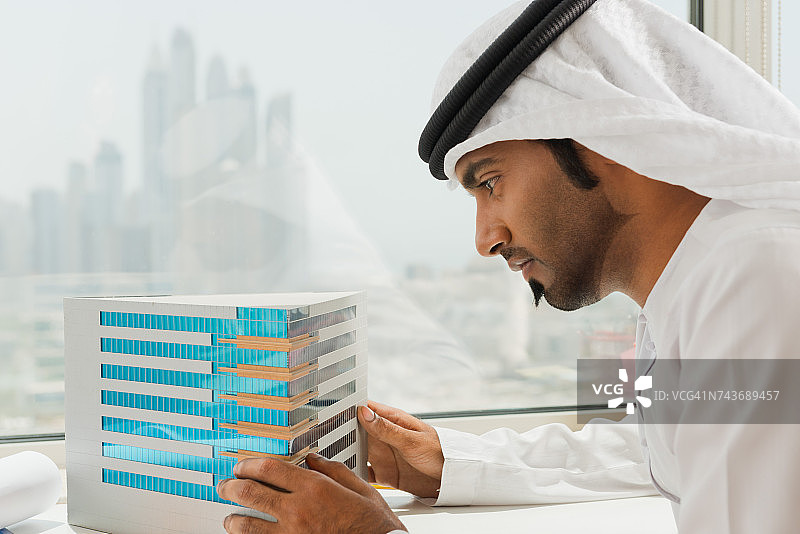 阿联酋商人在看建筑模型。图片素材