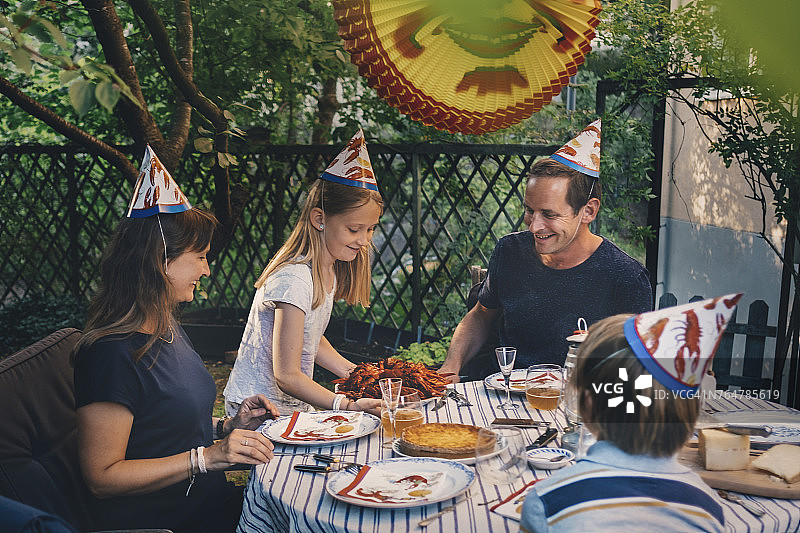 快乐的四口之家在院子里享受小龙虾派对图片素材