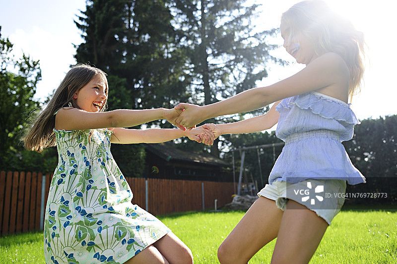 两个快乐顽皮的女孩在花园里图片素材