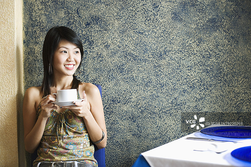 年轻女子正在餐厅里喝咖啡图片素材