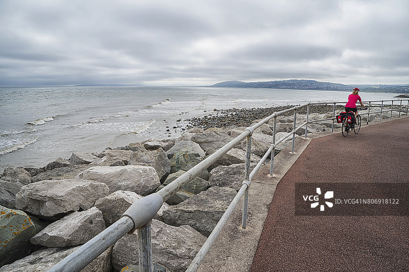 女性旅游自行车沿着海滨自行车道骑行图片素材