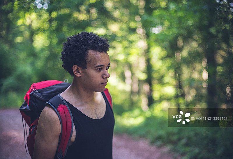 非洲黑人男孩在欧洲森林徒步旅行。图片素材