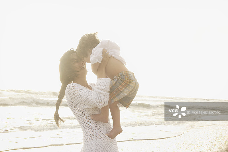 母亲抱着儿子在海滩上图片素材