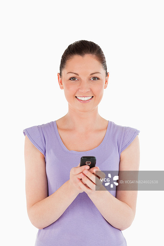 有魅力的女人站着用手机发短信图片素材