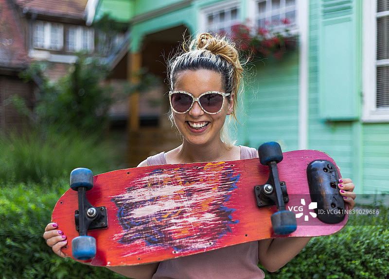 街道上微笑的滑板女孩图片素材