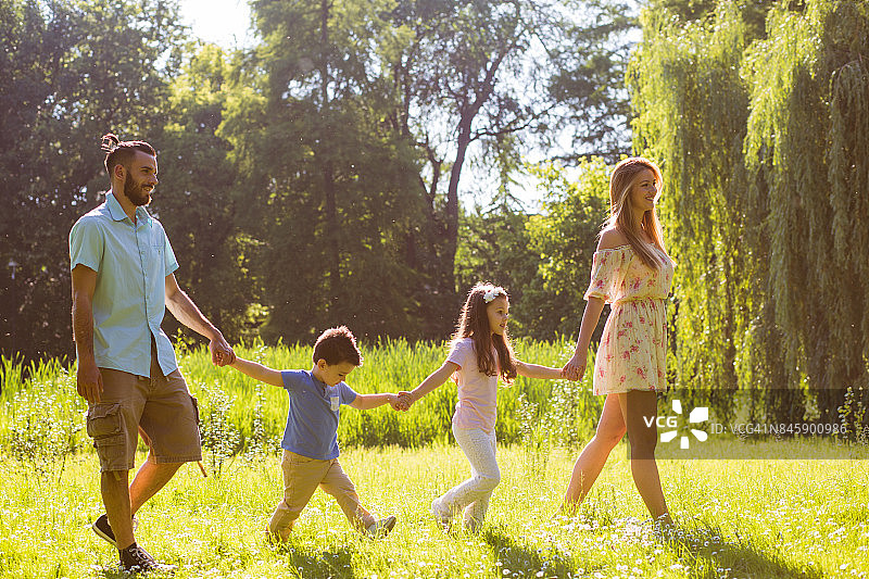 快乐的一家人享受着他们的春天漫步在大自然中图片素材
