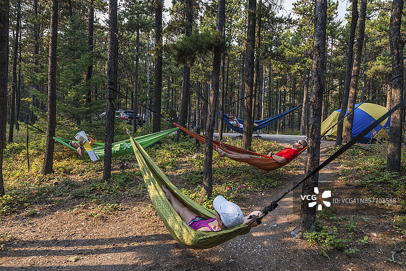 四名露营者在营地的吊床上休息图片素材