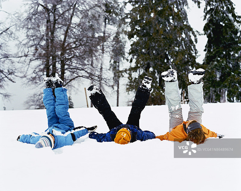 三个孩子在雪中玩耍图片素材