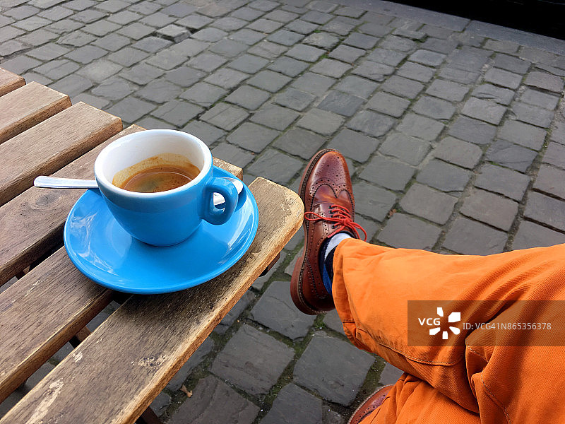欧洲人行道上的户外浓缩咖啡休息时间。五颜六色的杯子和裤子图片素材