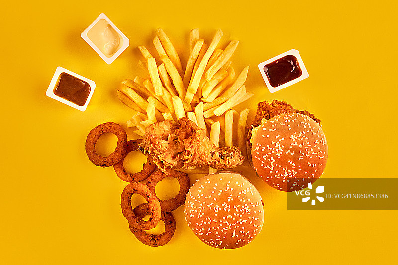 快餐和不健康的饮食概念-近距离快餐小吃在黄色的背景图片素材