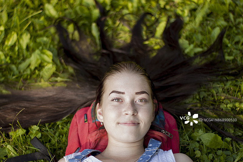 美丽的女孩躺在草地上图片素材
