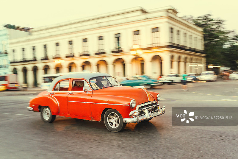 一辆老式美国汽车在古巴哈瓦那的街道上行驶图片素材
