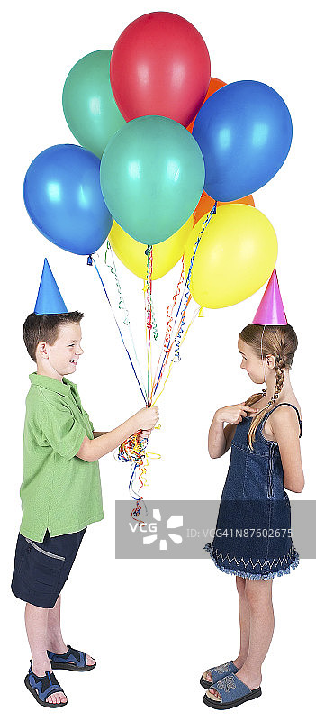 男孩和女孩拿着气球在白色的背景下图片素材