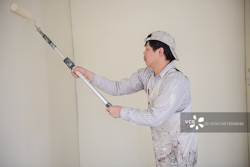 一位男油漆工正在粉刷房间图片素材