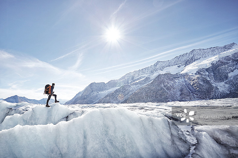瑞士阿莱奇冰川上的远山徒步旅行者图片素材