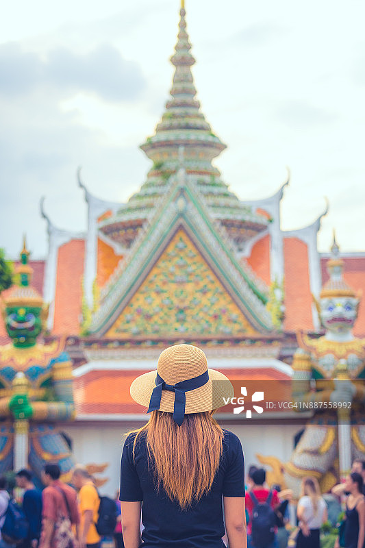 后视图，一个年轻的女游客参观寺庙在泰国。亚洲图片素材
