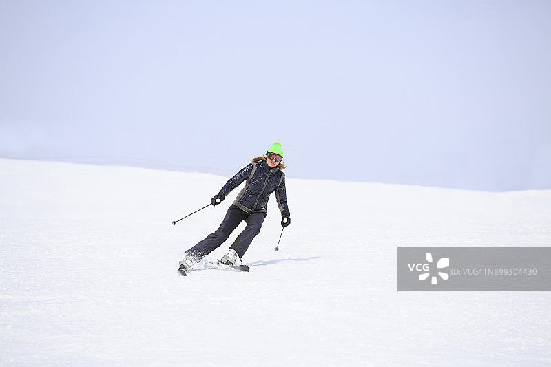 女子滑雪滑雪在阳光明媚的滑雪胜地业余冬季运动图片素材