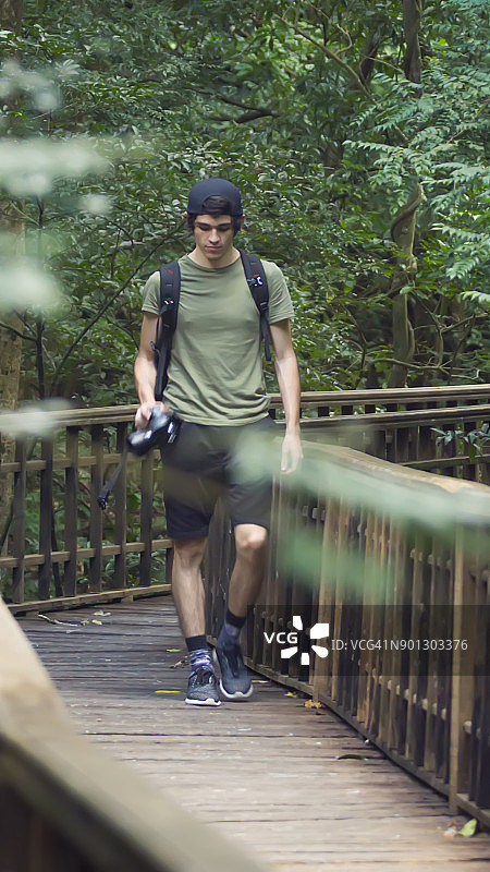 一个年轻人背着背包在热带雨林徒步旅行图片素材