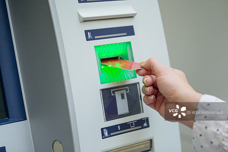 在ATM机里推信用卡的女人图片素材