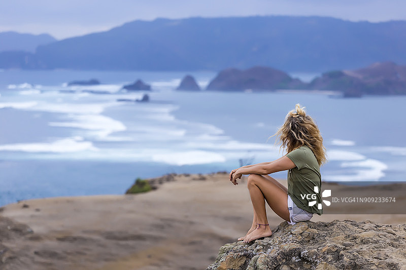 印度尼西亚，龙目岛，一个女人坐在海边看风景图片素材