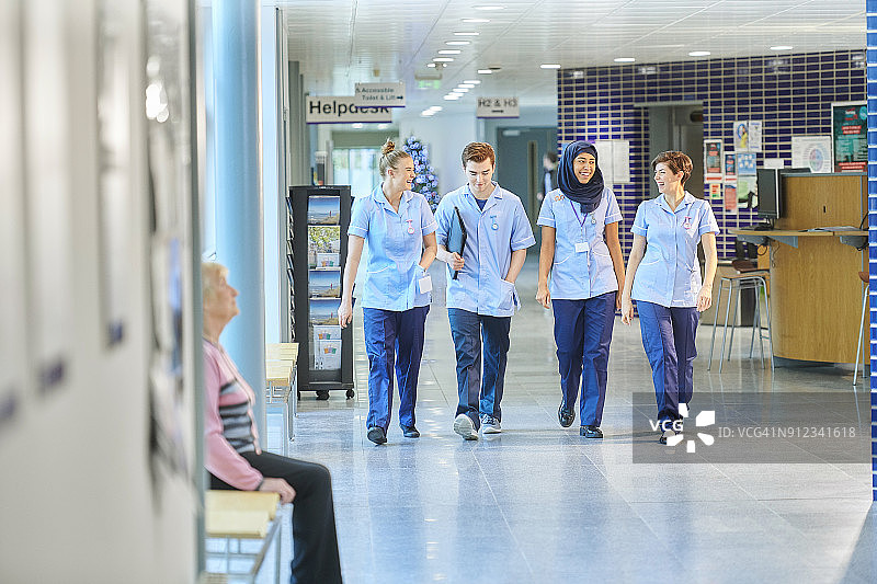 年轻的护士在去病房的路上聊天图片素材