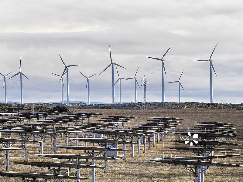 在西班牙的阿尔瓦塞特，卡西亚拉曼查，风景中的风力涡轮机和太阳能电池板，两种“绿色”可再生能源在冬季在一块土地上图片素材