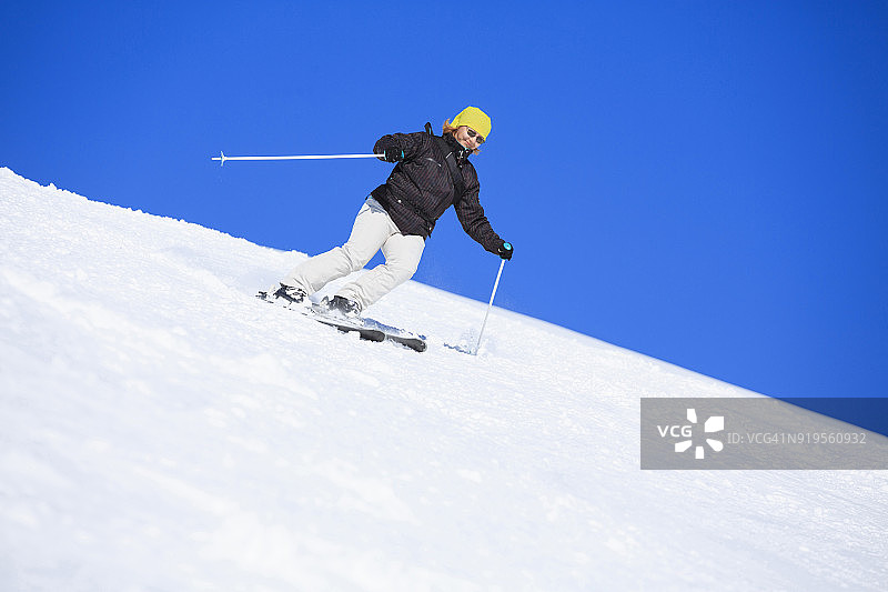 业余冬季运动女子滑雪者滑雪在阳光明媚的滑雪胜地Dolomites在意大利图片素材