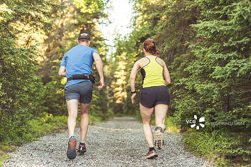 一对中年夫妇在森林里跑步图片素材