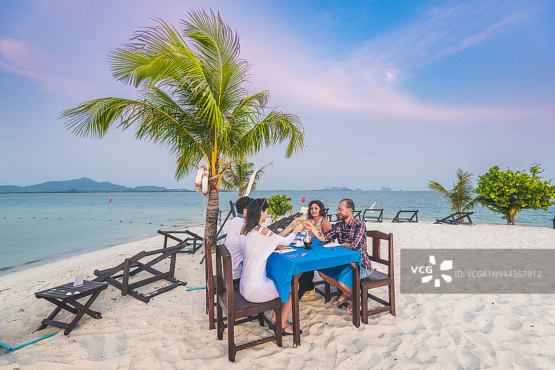 一群朋友在泰国的海滩上用餐。图片素材