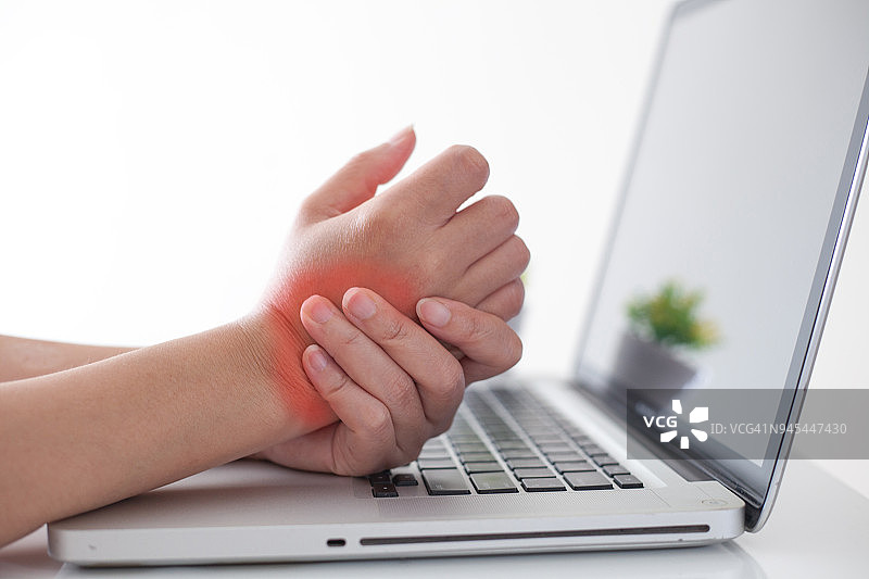 一位女士因使用电脑而手腕疼痛。,手痛图片素材